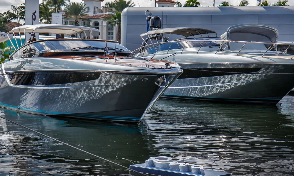 Two dark grey mega-yachts docked at the boat show